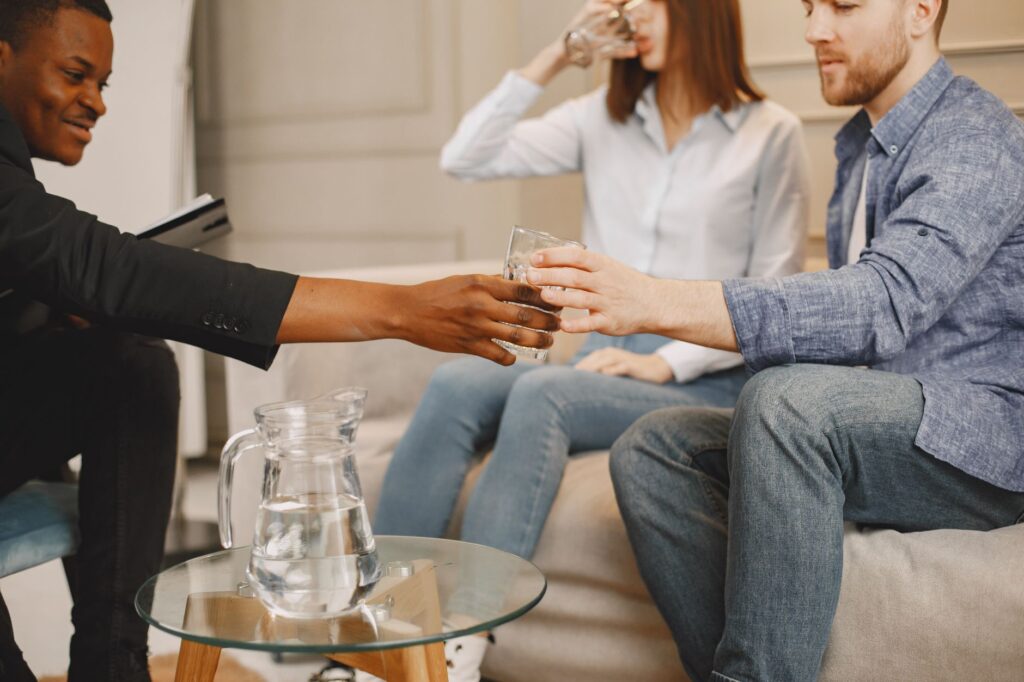 therapist handing man glass of water
